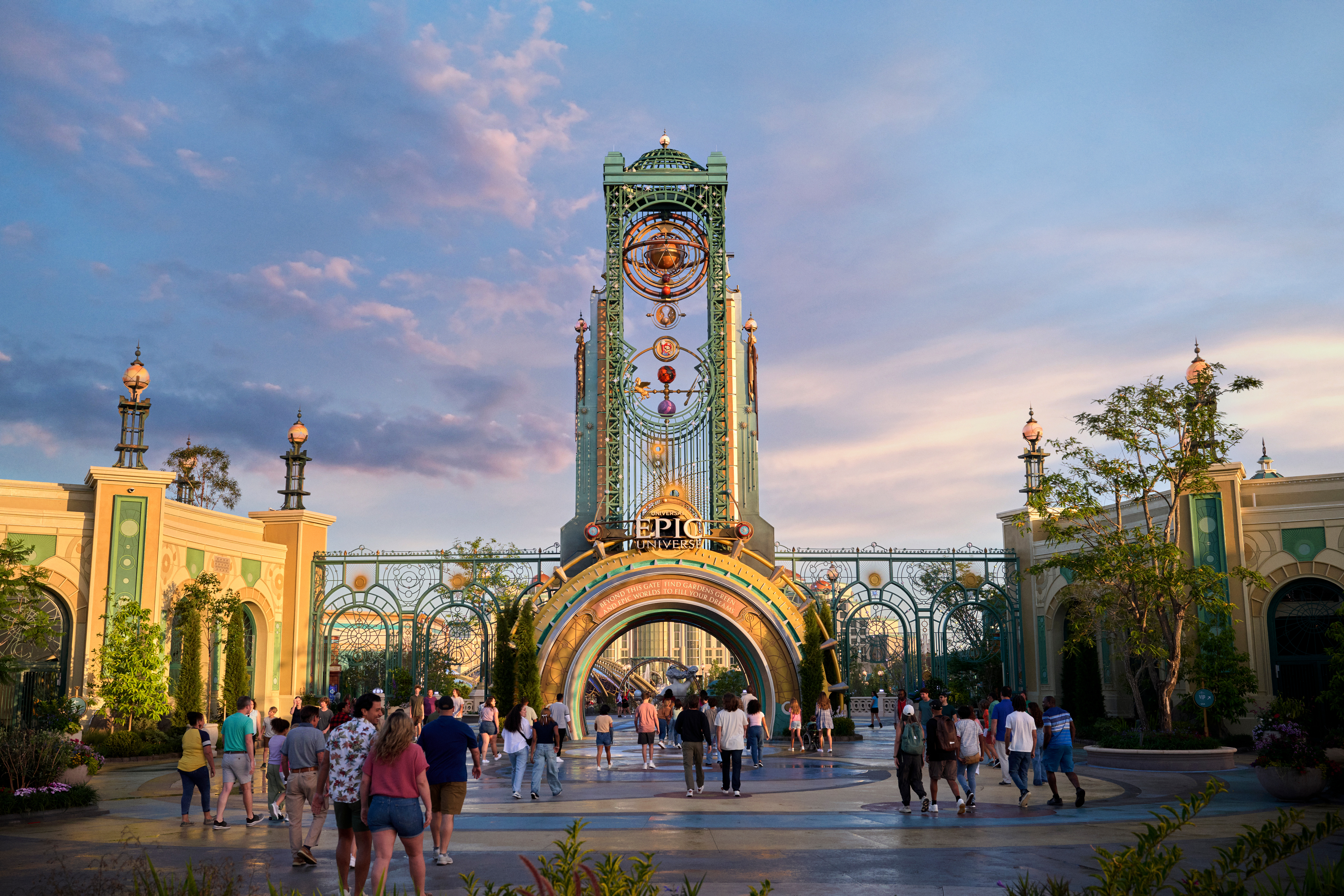 Entrée principale d’Epic Universe à Universal Orlando Resort, avec une architecture spectaculaire, des visiteurs entrant dans le parc et une ambiance immersive au coucher du soleil, symbole de la nouv